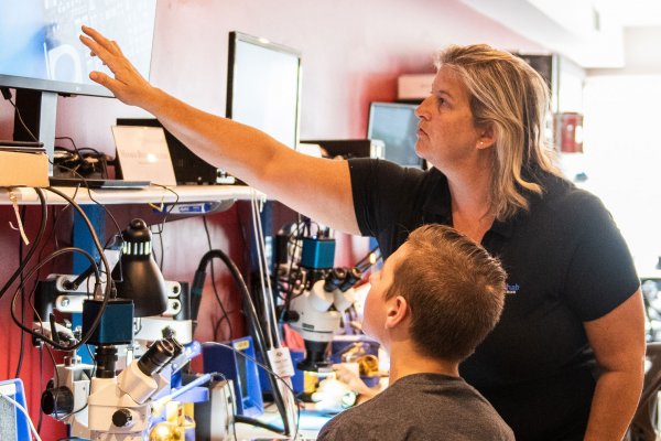 Jessa Jones shows Moses Buckwalter a circuit board at iPad Rehab